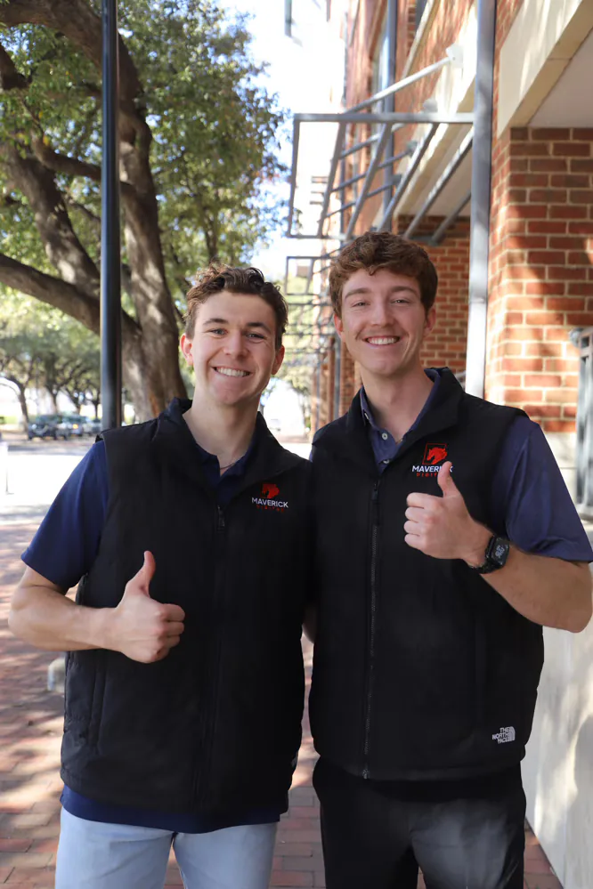 Two Maverick Digital team members giving a thumbs-up outdoors