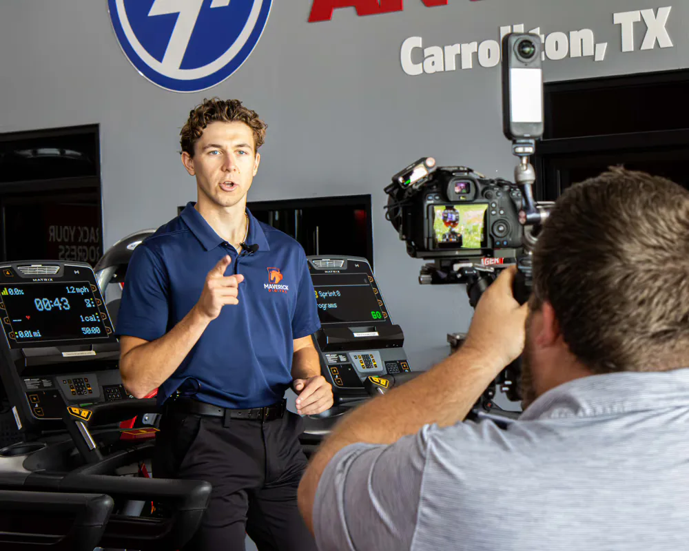 Maverick Digital team member filming a video ad inside a Carrollton, TX gym