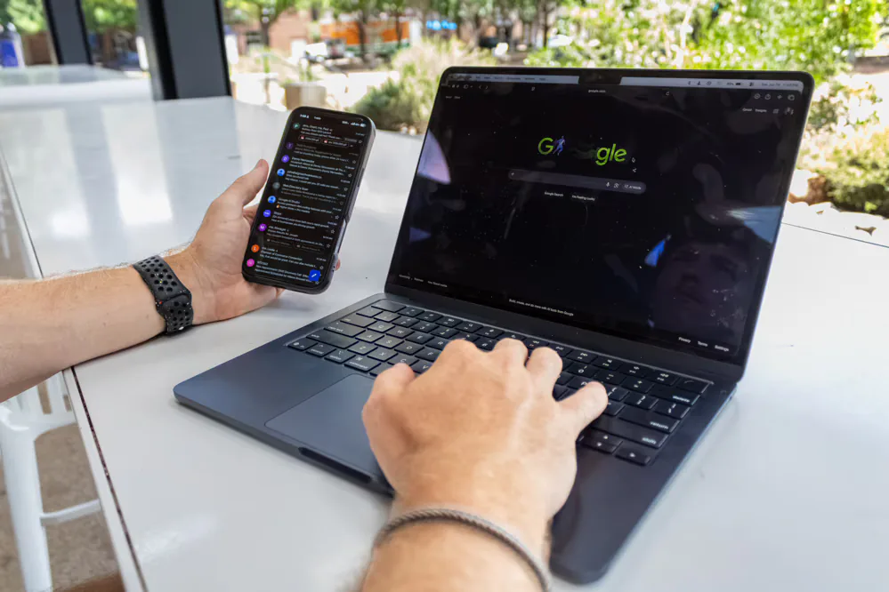 Person searching Google on a laptop and a smartphone