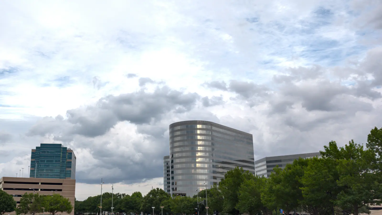 Addison office towers seen from street level under heavy cloud