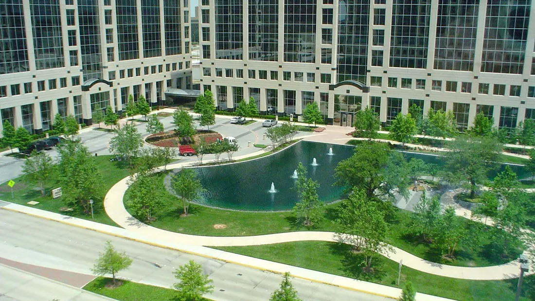 JPMorgan International Plaza in Farmers Branch: glass office towers behind a fountain pond, lawns and curving paths