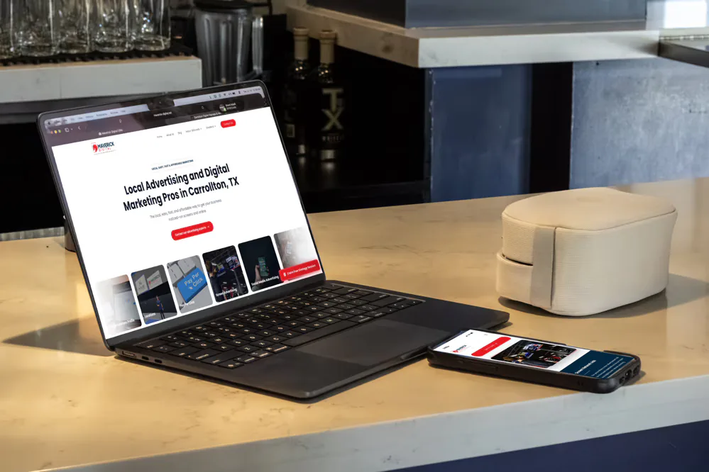 Laptop and phone showing the Maverick Digital website on a café counter