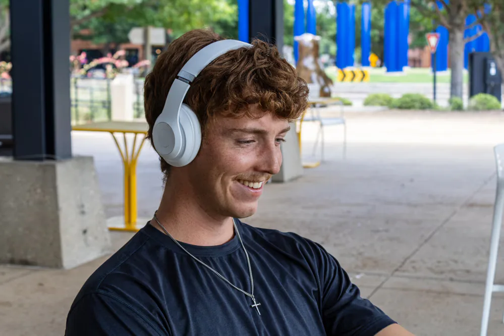 Smiling listener wearing headphones outdoors
